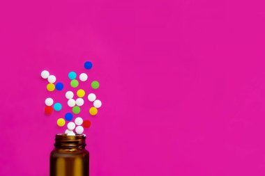 Çeşitli ilaç hapları, tabletler, kapsüller ve arka planda bir şişe. Metin için alanı kopyala