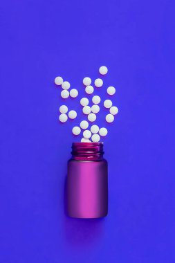 Çeşitli ilaç hapları, tabletler, kapsüller ve arka planda bir şişe. Metin için alanı kopyala