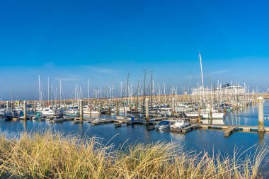IJmuiden, Hollanda - 29 Mart 2022: Günbatımına yakın güneşli bir günde tekneli kuzey denizi ve marina.