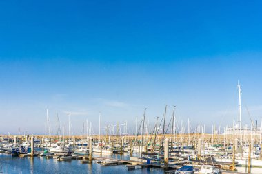 IJmuiden, Hollanda - 29 Mart 2022: Günbatımına yakın güneşli bir günde tekneli kuzey denizi ve marina.