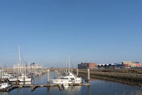 Эймсбери, Нидерланды - 29 марта 2022 года: Северное море и пристань с лодками в красивый солнечный день, близкий к закату.