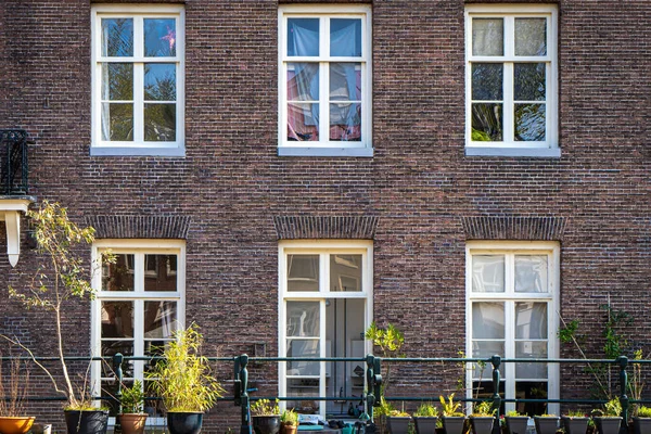 Типичные Дома Канале Знаменитыми Столбами Амстердаме Вдоль Тротуара — стоковое фото