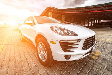 Compact white executive car, with business car, large chrome grille.