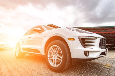 Compact white executive car, with business car, large chrome grille.