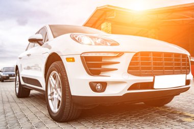 Compact white executive car, with business car, large chrome grille.