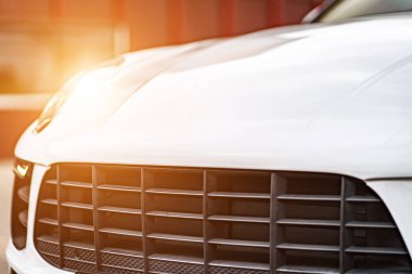 Compact white executive car, with business car, large chrome grille.