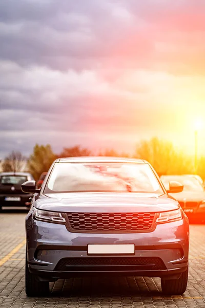 Predatory car headlight with blue lights and hood of powerful grey blue car sports car with matte grey paint and wheel