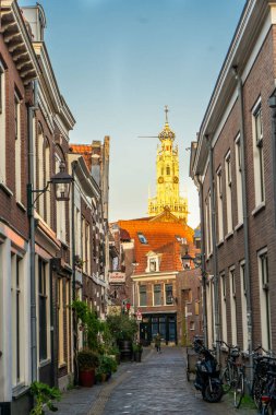 Haarlem, Hollanda - Mart 2022: Haarlem 'in tarihi şehir merkezinde tuğla binalar bulunan dar kaldırım taşı caddesi