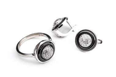 Gümüş mücevher seti ve taştan beyaz arka planı olan gümüş küpeler. Gümüş mücevher koleksiyonu