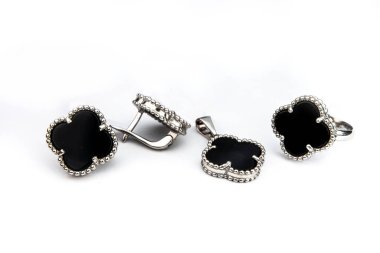 Gümüş mücevher seti ve taştan beyaz arka planı olan gümüş küpeler. Gümüş mücevher koleksiyonu