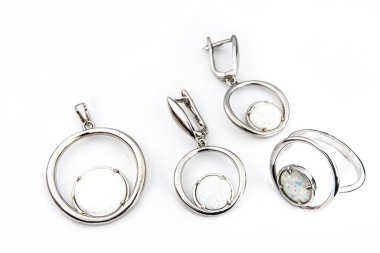 Gümüş mücevher seti ve taştan beyaz arka planı olan gümüş küpeler. Gümüş mücevher koleksiyonu