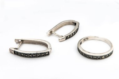 Gümüş mücevher seti ve taştan beyaz arka planı olan gümüş küpeler. Gümüş mücevher koleksiyonu