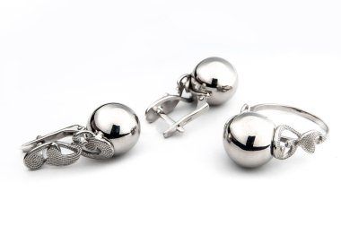 Gümüş mücevher seti ve taştan beyaz arka planı olan gümüş küpeler. Gümüş mücevher koleksiyonu