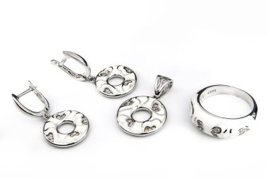 Gümüş mücevher seti ve taştan beyaz arka planı olan gümüş küpeler. Gümüş mücevher koleksiyonu