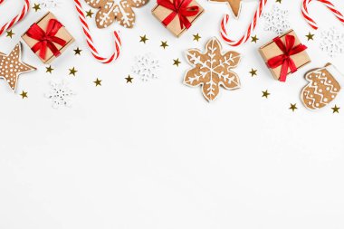 hediye kutuları, şeker kamışı, zencefilli kurabiye, kar taneleri ve konfeti açık arkaplanda, noel kompozisyonu