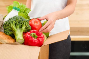 Kadın paketleri kutudan çıkarır, eve teslim eder.