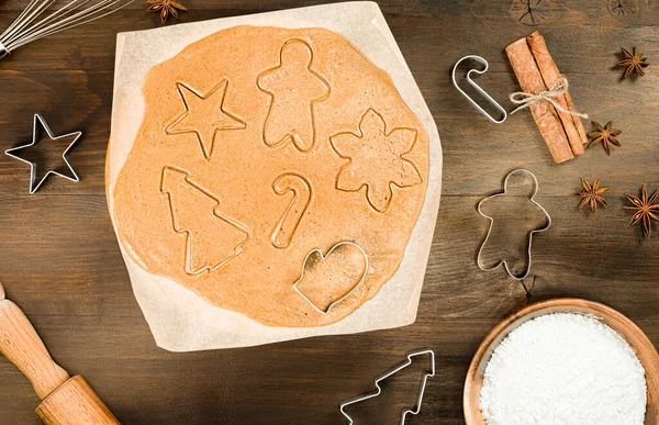 Christmas cookie dough, ingredients and cookie cutters on wooden table