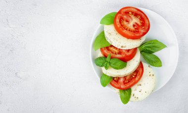 Gri beton bir masada Caprese salatası