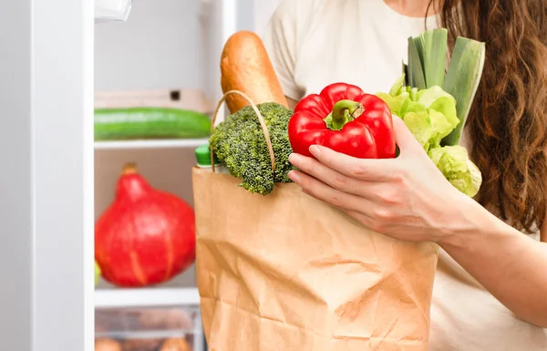 Женщина Берет Свежие Овощи Бумажного Пакета Кладет Холодильник — стоковое фото