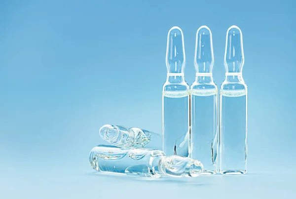 Five Transparent Ampoules Medicine Blue Background — стоковое фото