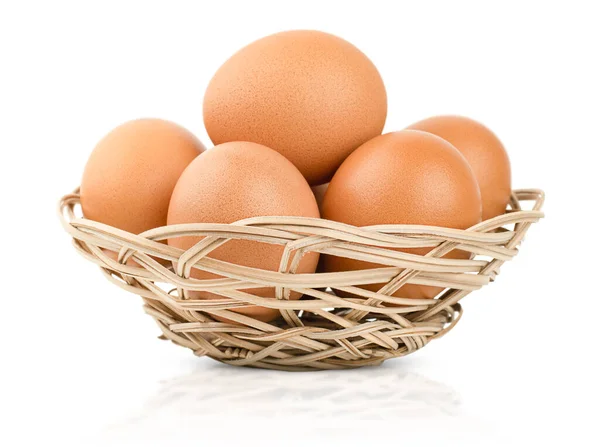 在孤立的白色背景上有鸡蛋的柳条盘 免版税图库图片