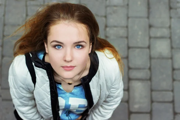 Jeune belle fille aux yeux bleus et aux cheveux roux marchant dans les rues — Photo