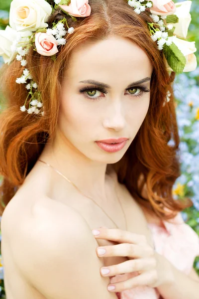 Giovane attraente ragazza sexy in una giornata di sole di fioritura con fiori in capelli rossi — Foto Stock