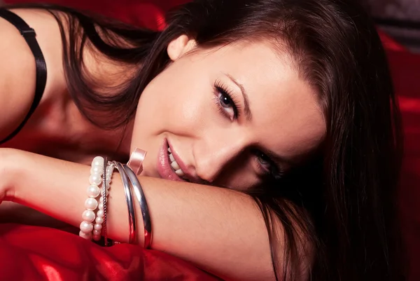 A beautiful young girl with a smile brunette in the bedroom — Stock Photo, Image