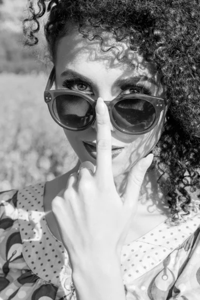 Portrait of a young beautiful little curly-headed girl in sunglasses in the field — Stock Photo, Image