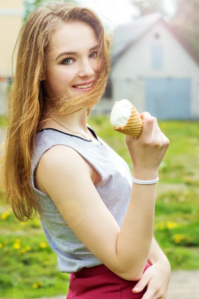 Junges schönes glückliches Mädchen an einem sonnigen Tag, das durch die Stadt spaziert und Eis isst — Stockfoto