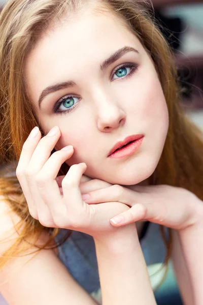 Дорогая красивая элегантная молодая девушка с голубыми глазами и сидящими за столом волосами режима — стоковое фото