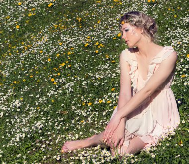 çiçeklenme tree yakınındaki ormanda uzun saçlı sarışın güneşli gün ve makyaj çiçekler mavi gözlü arasında duran genç güzel şık, çekici kız