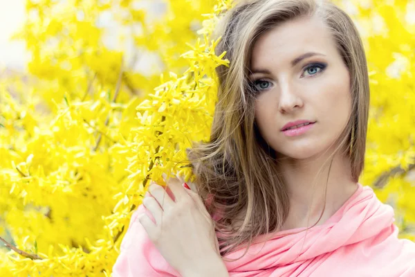 Hermosa novia elegante chica en una chaqueta rosa cerca de arbusto con flores amarillas —  Fotos de Stock