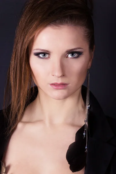 Retrato de uma bela garotas elegantes em fundo preto no estúdio com um brinco no ouvido — Fotografia de Stock