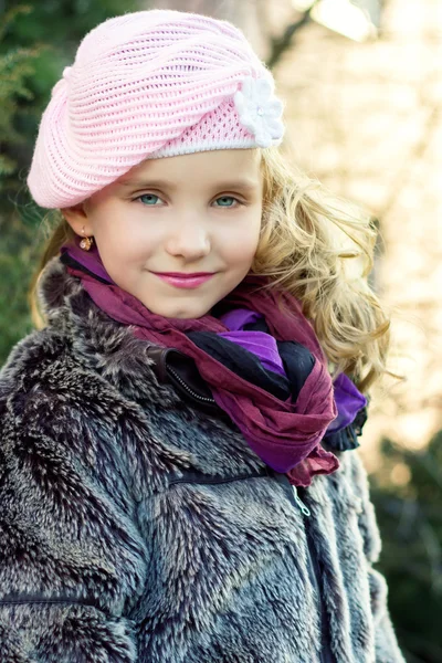 Niña hermosa con ojos azules en sombrero rosa de pie en la calle — Foto de Stock