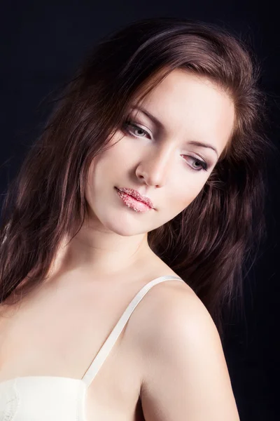 Linda jovem sexy morena com maquiagem no bodysuit branco no estúdio em um fundo preto — Fotografia de Stock