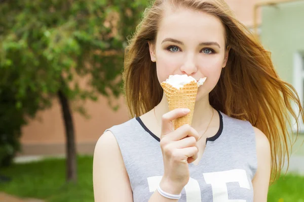 Junge schöne glückliche Mädchen mit langen Haaren an einem sonnigen Tag zu Fuß durch die Stadt und Eis essen — Stockfoto