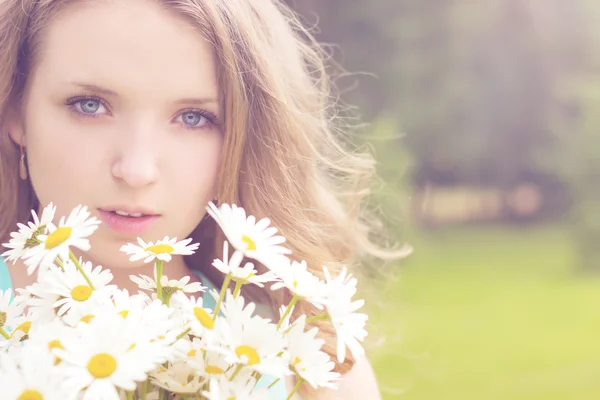 Bella ragazza con un mazzo di margherite con i capelli bianchi si trova in un parco in una giornata estiva soleggiata — Foto Stock