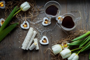 Sevgililer Günü 'nde tatlı ve lale çiçekli iki fincan kahve.