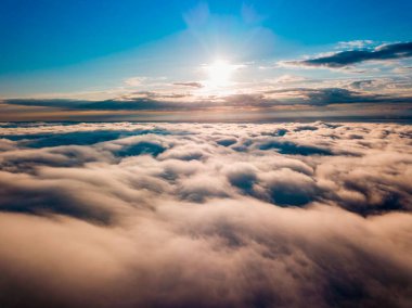 Dağlardaki sislerin üzerinden yüksek uçuş. Sabah Ukraynalı Karpatlar. Hava aracı görünümü.