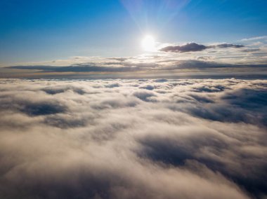 Dağlardaki sislerin üzerinden yüksek uçuş. Sabah Ukraynalı Karpatlar. Hava aracı görünümü.