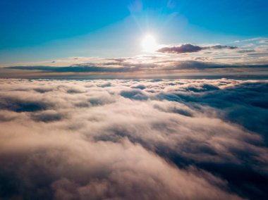 Dağlardaki sislerin üzerinden yüksek uçuş. Sabah Ukraynalı Karpatlar. Hava aracı görünümü.