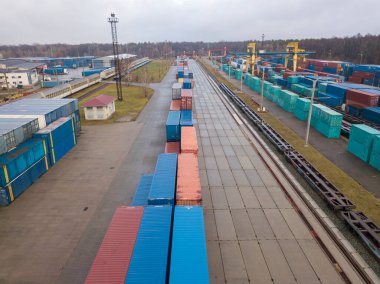 Demiryolu gümrüğünde çok renkli konteynırlar var. Hava aracı görünümü.