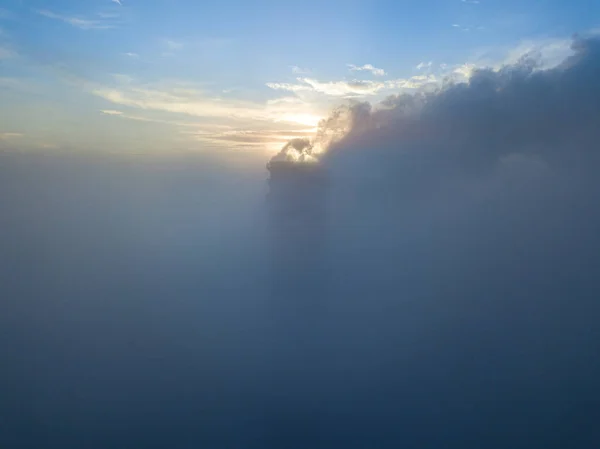 夕日の光の中で霧の上の火力発電所の高い煙突 空中ドローンビュー — ストック写真