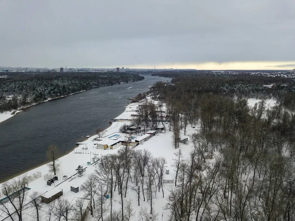 Karlı kışta şehirde bir nehir. Hava aracı görünümü.
