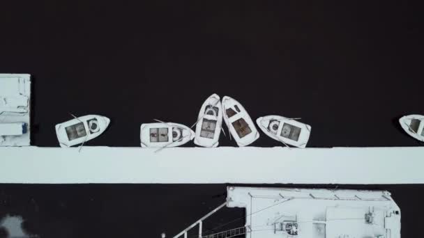 雪の水の中の桟橋にボート覆われた 空中ドローンのトップビュー — ストック動画