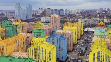 Bulutlu havada Kiev 'deki çok renkli konutların üzerinden uçun. Hava aracı uçuşu.