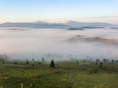 Ukrayna Karpatları 'nda sisin üstünde gün doğumu. Hava aracı görünümü.