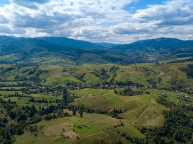 Yazın Ukrayna Karpatları 'nın yeşil dağları. Yamaçlarda kozalaklı ağaçlar. Hava aracı görünümü.