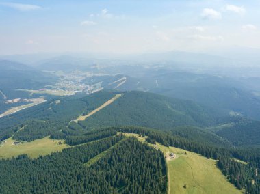 Yazın Ukrayna Karpatları 'nın yeşil dağları. Güneşli bir gün, nadir bulutlar. Hava aracı görünümü.